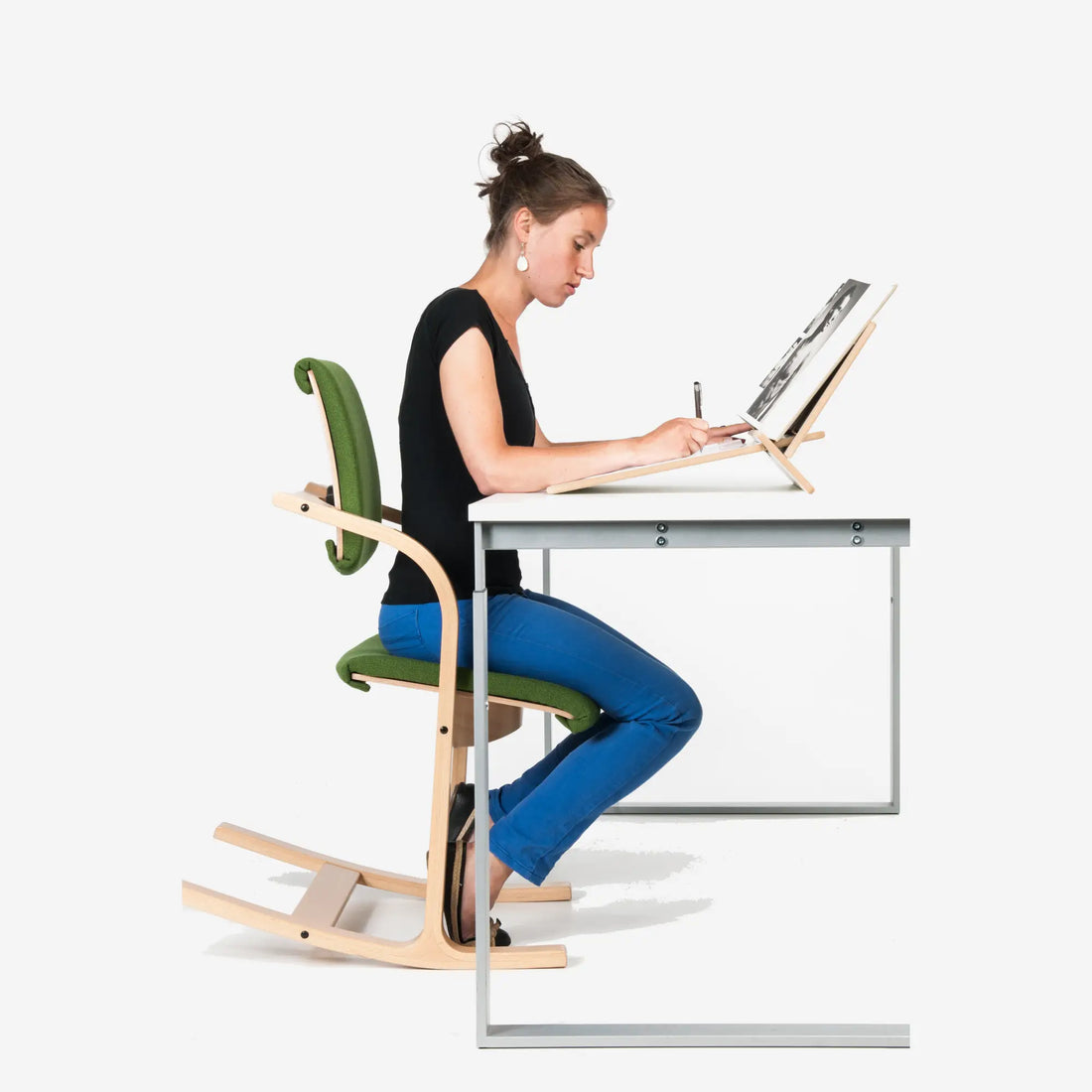 Kind aan een in hoogte verstelbaar bureau met het scherm op ooghoogte en de voeten gesteund