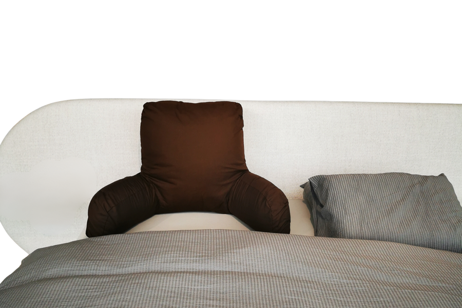 Leeskussen in bed tussen de hoofdkussens
