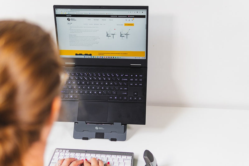 Laptop op een laptopstandaard met een los toetsenbord en een losse muis ervoor